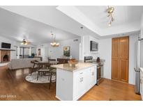 Open-concept kitchen and dining area with granite countertops, stainless steel appliances, and wood flooring at 3031 N Civic Center Plz # 317, Scottsdale, AZ 85251