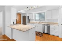 Modern kitchen boasts stainless steel appliances, granite countertops, and wood flooring at 3031 N Civic Center Plz # 317, Scottsdale, AZ 85251