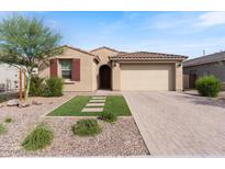 Charming home featuring a two-car garage, desert landscaping, and a cozy, inviting entrance at 32567 N 133Rd Ave, Peoria, AZ 85383