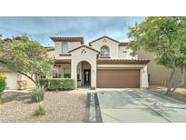 Charming two-story home featuring a well-manicured lawn and a two-car garage at 4328 W Judson Dr, New River, AZ 85087