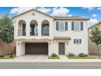 Beautiful two-story home featuring stucco siding, a two-car garage and arched doorway to a charming balcony at 4353 E Erie St, Gilbert, AZ 85295