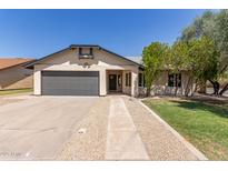 Charming single-story home featuring a gray garage door and manicured front yard at 45 S Rita Ln, Chandler, AZ 85226