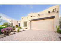 Beige home with pavers, cacti and rock landscaping, plus a neutral garage and desert touches at 5520 E Desert Forest Trl, Cave Creek, AZ 85331