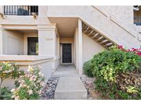 Charming entryway with desert landscaping, stairs, and a secure black metal screen door at 9708 E Via Linda Rd # 1350, Scottsdale, AZ 85258