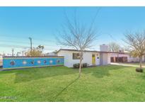 Charming single-story home featuring a bright yellow front door and a beautifully manicured lawn at 12453 N 29Th Ave, Phoenix, AZ 85029