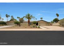 Charming single-story home featuring a neutral color palette, desert landscaping, and a spacious driveway at 14014 N 57Th Way, Scottsdale, AZ 85254