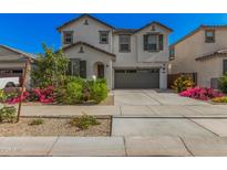 Charming two-story home featuring a well-manicured front yard and a two-car garage at 14253 W El Cortez Pl, Surprise, AZ 85387