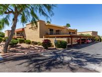 Exterior view of property with carports, landscaping, and palm trees at 16336 E Palisades Blvd # 4, Fountain Hills, AZ 85268