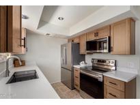 Modern kitchen with stainless steel appliances, white countertops and tile floor at 16336 E Palisades Blvd # 4, Fountain Hills, AZ 85268