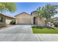 Attractive single-story home featuring a two-car garage, manicured lawn, and mature trees at 17789 W Bridger St, Surprise, AZ 85388
