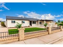 Charming single-story home with brick fence, gravel yard, and green turf in front of house at 1852 N Grand St, Mesa, AZ 85201