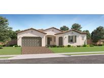 Charming single-story home featuring a brick driveway and a well-maintained front yard with lush landscaping at 23134 E Nightingale Rd, Queen Creek, AZ 85142