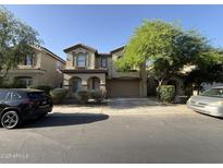 Inviting two-story home showcasing well-manicured landscaping, arched entryway, and a two-car garage at 6341 W Valencia Dr, Laveen, AZ 85339