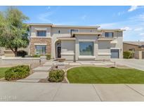 Beautiful two story home featuring stone accents, nice lawn, and a walkway leading to the front door at 7129 S Stadium Way, Gilbert, AZ 85298