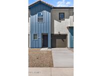 Charming townhome with a blue accent wall, two windows, gravel landscaping, and a one-car garage at 7434 S 75Th Dr, Laveen, AZ 85339