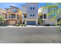 Modern townhomes featuring two-story designs with attached garages and landscaped front yards at 751 W Flintlock Way, Chandler, AZ 85286