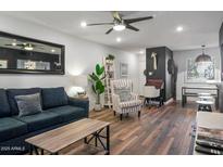 Bright living room with a blue couch, accent chair, and sleek ceiling fan at 7625 E Camelback Rd # 310B, Scottsdale, AZ 85251