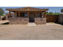 Charming single-story home featuring a stone accent wall and covered front porch at 7930 E Broadway Rd, Mesa, AZ 85208