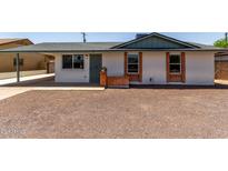 Charming single-story home featuring a brick accent, gravel landscaping, and a covered carport at 927 E Greenway Rd, Phoenix, AZ 85042