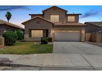 Two-story home featuring a well-kept lawn and two-car garage on a concrete driveway at 12426 W Adams St, Avondale, AZ 85323