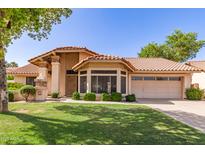 Charming home showcasing a well-maintained lawn, tile roof, mature landscaping, and an attached two-car garage at 1258 E Granada St, Mesa, AZ 85203