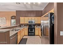 Well-lit kitchen featuring stainless steel appliances, ample cabinetry, and a convenient breakfast bar area at 1350 S Greenfield Rd # 2205, Mesa, AZ 85206