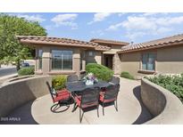 Charming patio with black metal table, chairs, and lovely landscaping, perfect for outdoor dining and relaxation at 16974 W Marcos De Niza Dr, Surprise, AZ 85387