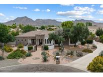 Stunning home featuring a desert landscape, tile roof, stone accents, and picturesque mountain views at 21205 E Excelsior Ave, Queen Creek, AZ 85142