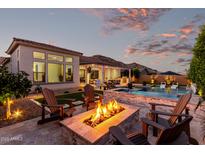 Outdoor entertaining space featuring a pool, built-in grill, and a cozy fire pit with seating at 21449 W Mariposa St, Buckeye, AZ 85396