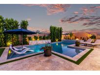 Backyard pool area with lounge chairs and lush landscaping, creating a serene and relaxing oasis at 21449 W Mariposa St, Buckeye, AZ 85396