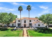 Stunning two-story home boasts a terracotta roof, palm trees, and a meticulously manicured lawn at 2339 E Virgo Pl, Chandler, AZ 85249
