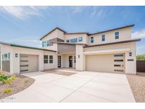 Modern two-story home featuring a three-car garage, neutral stucco, and contemporary design elements, set against a bright blue sky at 35234 N Barley St, San Tan Valley, AZ 85144