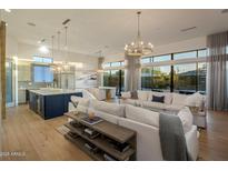 Open concept living space with hardwood floors, large windows, and a seamless flow to kitchen and dining at 3626 N Mohave Way, Scottsdale, AZ 85251