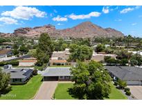 An aerial view showcasing the home, mature trees, and stunning mountain views beyond at 4510 E Calle Tuberia --, Phoenix, AZ 85018