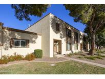 Charming townhome with a well-maintained lawn and colorful flower beds, complemented by mature shade trees at 5111 N 83Rd St, Scottsdale, AZ 85250