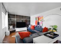 Inviting living room with a modern blue sectional, vibrant artwork, and stylish decor, perfect for relaxation and entertainment at 6906 E 4Th St # 4, Scottsdale, AZ 85251