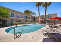 Serene community pool with inviting lounge chairs and umbrellas, ideal for relaxation in a lush setting at 6906 E 4Th St # 4, Scottsdale, AZ 85251