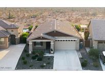 Charming single-Gathering home boasts a desert landscape, covered porch and a two car garage at 7618 S Lone Pine Pl, Gold Canyon, AZ 85118