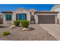 Charming single-story home with a tile roof, green shutters, and an attached two car garage at 9678 W Patrick Ln, Peoria, AZ 85383