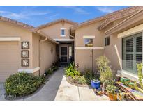 Inviting front entrance featuring beautiful Southwestern landscaping and neutral stucco exterior with lovely flower artwork at 10359 E Los Lagos Vista Ave, Mesa, AZ 85209
