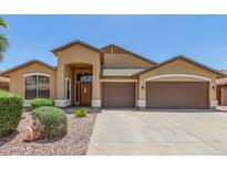 Charming single-story home showcasing a three car garage and desert landscaping at 11303 E Pratt Ave, Mesa, AZ 85212