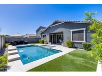 Beautiful backyard oasis showcasing a refreshing pool, patio and lush artificial grass at 13171 W Redstone Dr, Peoria, AZ 85383