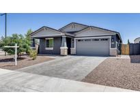Charming single-Gathering home featuring a gray exterior, a two-car garage, and a well-maintained front yard at 13171 W Redstone Dr, Peoria, AZ 85383
