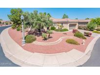 Lovely home featuring desert landscaping, mature trees, and a sidewalk and street lamppost at 13444 W Cabrillo Dr, Sun City West, AZ 85375