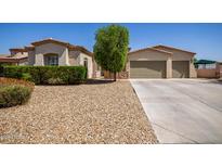 Charming home featuring a desert landscape, a three-car garage and a lush tree providing shade at 1804 W Magdalena Ln, Phoenix, AZ 85041