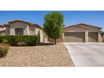 Charming home featuring a desert landscape, a three-car garage and a lush tree providing shade at 1804 W Magdalena Ln, Phoenix, AZ 85041