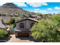 Beautiful two-story home featuring stone accents, arched windows, desert landscaping, and tile roof at 1922 E Everett Dr, Phoenix, AZ 85022