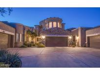 Inviting home exterior with a stone accent garage and desert landscaping at 19475 N Grayhawk Dr # 1039, Scottsdale, AZ 85255
