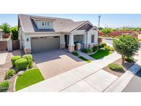 Beautiful single-Gathering home featuring stone accents, a well-manicured lawn, and a paver driveway and walkway at 2611 S Quaintance St, Gilbert, AZ 85295