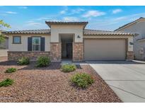 Charming single-story home features desert landscaping, stone accents, and a two-car garage at 28065 N 171St Dr, Surprise, AZ 85387